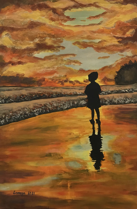 Boy watching sunset at the beach