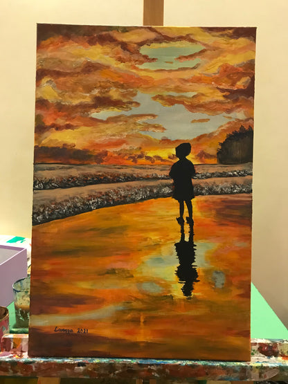 Boy watching sunset at the beach